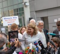 Advokat Roda Verheyen talar med media bredvid sin klient Lliuya från Peru på en skärm efter domen i målet om klimatskador som käranden, den peruanske jordbrukaren Luciano Lliuya, driver mot det tyska energibolaget RWE för dess koldioxidutsläpp, i den högre regionala domstolen i Hamm.