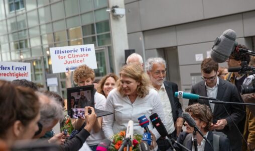 Advokat Roda Verheyen talar med media bredvid sin klient Lliuya från Peru på en skärm efter domen i målet om klimatskador som käranden, den peruanske jordbrukaren Luciano Lliuya, driver mot det tyska energibolaget RWE för dess koldioxidutsläpp, i den högre regionala domstolen i Hamm.