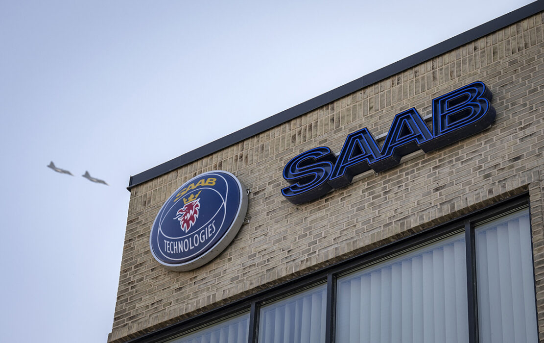 byggnad med Saaabs logga, två stridsplan på himlen