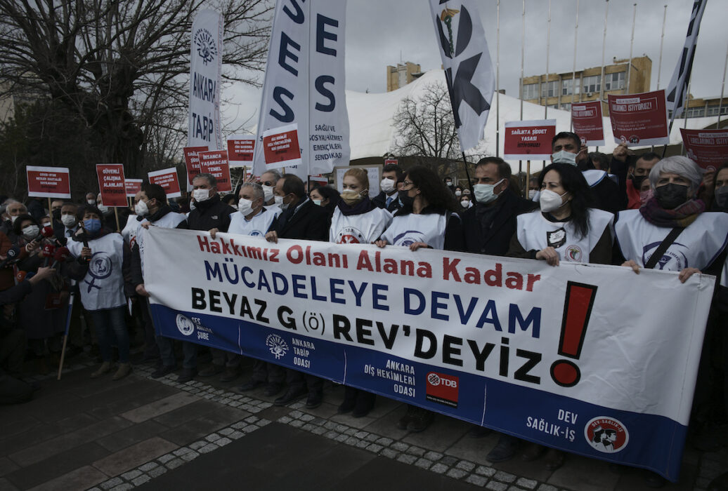 Stort demonstrationståg med banderoll, turkisk text