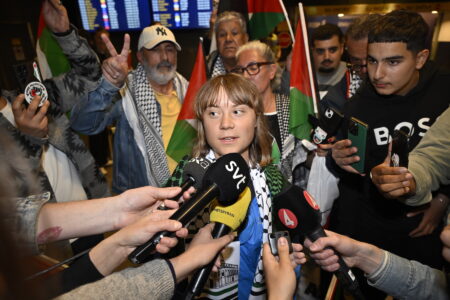 Greta Thunberg omringad av journalister.