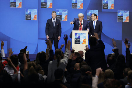 En grupp med uppsträckta händer framför Donald Trump.