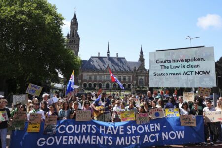 Aktivister med plakat utanför internationella domstolen i Haag.