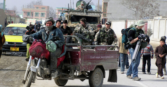 Svenska soldater åker pansarbil på en afghansk väg.