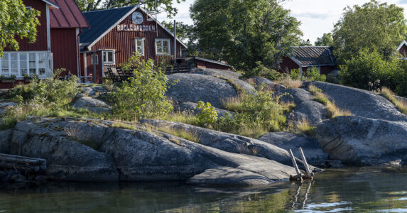 En skärgårdsö med ett par röda stugor varav en är öns butik.