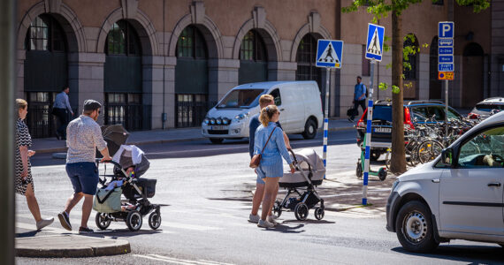 Föräldrar med barnvagnar på övergångsställe.