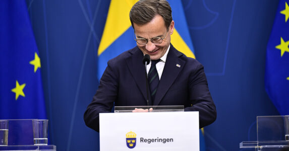 Ulf Kristersson skrattar och tittar ner.