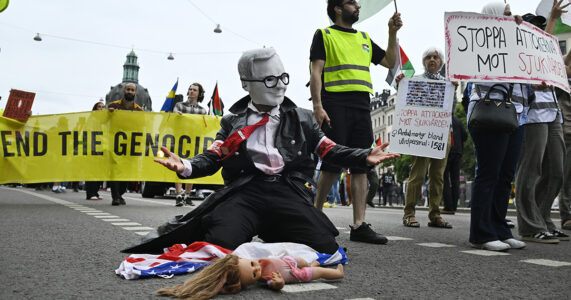 En Gaza-demonstration där en demonstrant är utklädd till Ulf Kristersson.