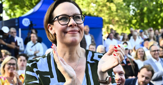 En kvinna i en publik utomhus på sommaren.