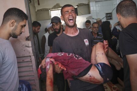 blodigt barn som bärs av en gråtande man