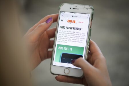 Mobiltelefon med Bris hemsida på skärmen.