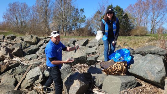 Två personer på klippor med plastpåsar.