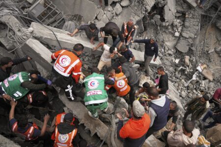 Volontärer räddningsarbetare letar efter kroppar i rasmassor.