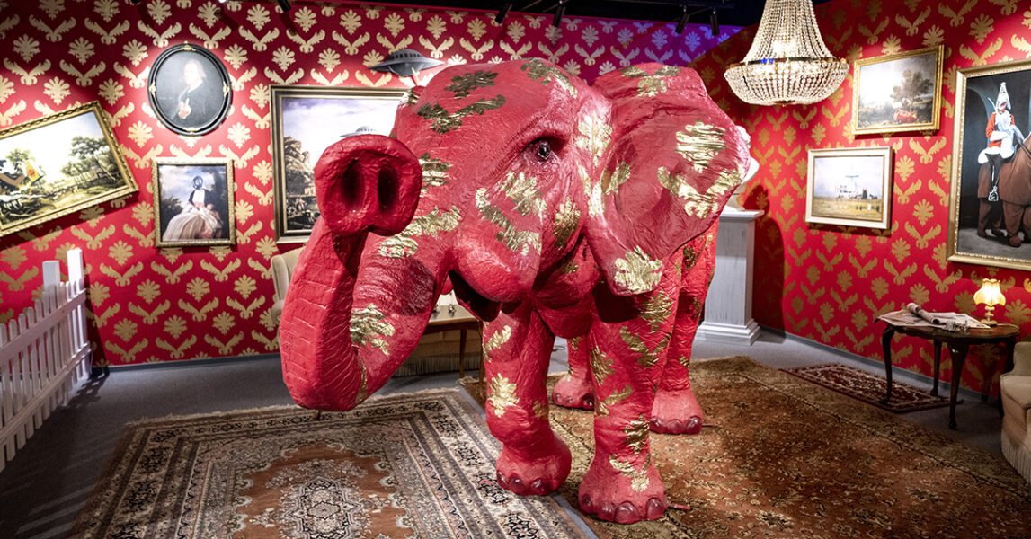 En elefant i rött och guld i ett rum i rött och guld.