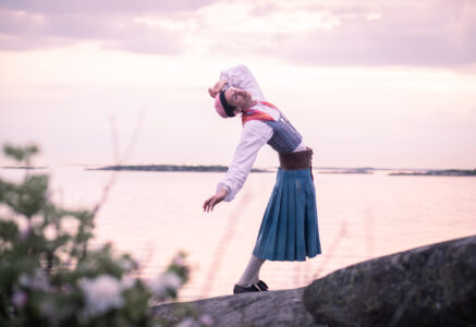 Person i folkdräkt på klippa