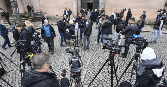 En massa reportrar på en gård.