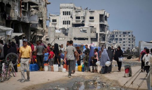 I sommarvärmen står palestinier i kö för att hämta vatten från en distributionspunkt i Gaza City, tisdag 12 augusti 2025.
