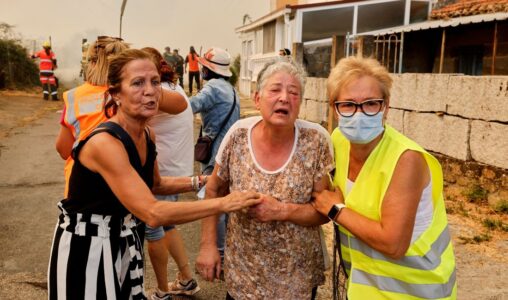 En äldre kvinna evakueras under en skogsbrand i Veiga das Meas, nordvästra Spanien.