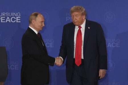 Vladimir Putin och Donald Trump skakar hand.