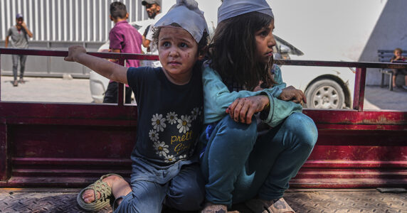 Två skadade flickor med bandage på ett lastbilsflak.