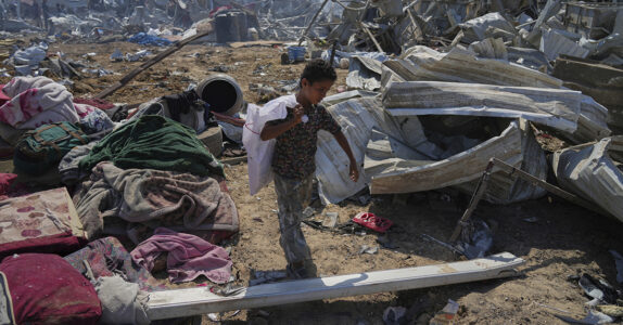 En liten pojke bland resterna av ett flyktingläger.