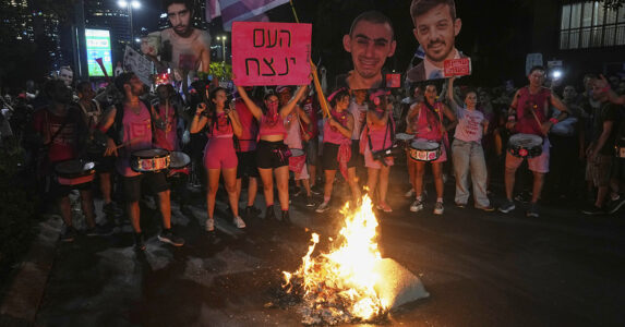 Demonstranter vid en eld på en väg.