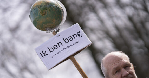 En man med ett plakat med ett jordklot.