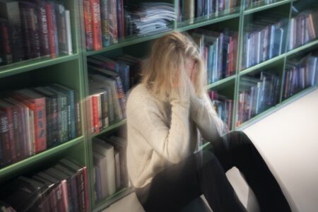 En tjej sitter på golvet och mår dåligt.