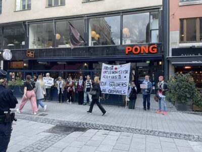 Ett tiotal deltagare står uppradade med två banderoller i en demonstration.