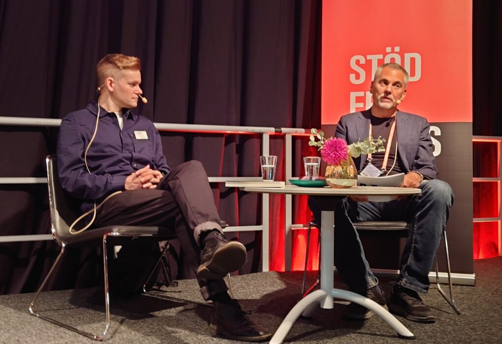 Joakim Medin och Erik Larsson samtalar på scenen.