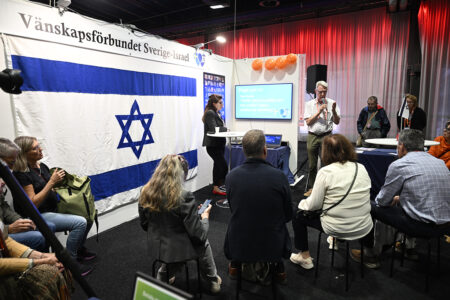 Israelflagga i monter på bokmässan, folk