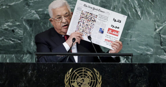 En man håller upp en tidningssida.