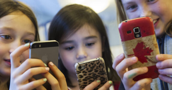 Tre flickor med mobiler.