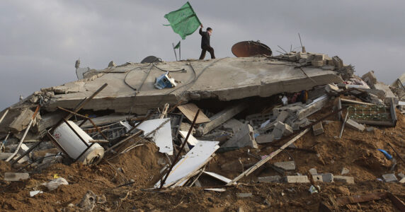 En pojke med en flagga på ruiner.