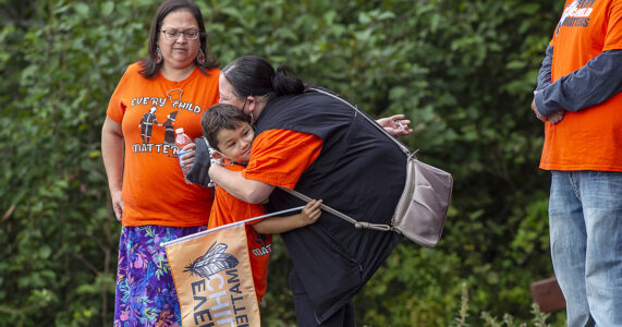 En pojke får en kram av en kvinna.