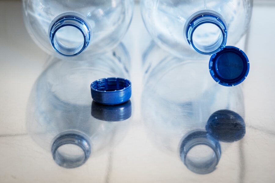 Petflaskor med och utan fastsittande plastlock.