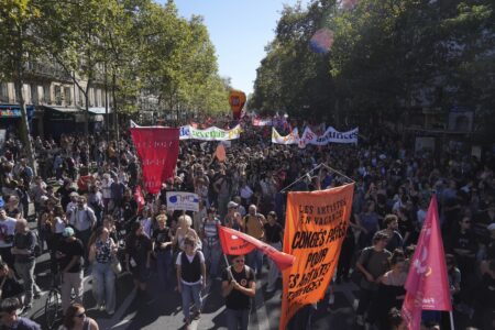 En gata fylld av demonstrerande personer med banderoller.