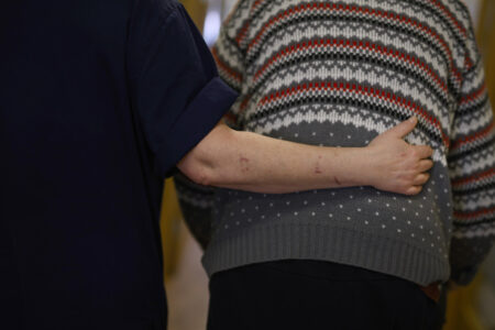 kvinna håller armen om en gamling