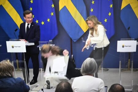 Sjukvårdsministern faller framåt under en presskonferens.