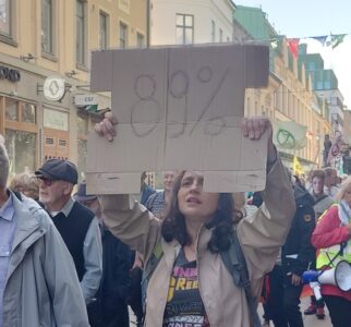 En klimatdemonstrant håller upp en skylt med texten 89 procent.