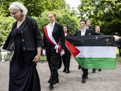 David Alcer hållandes en palestinaflagga under sin doktorspromotion.