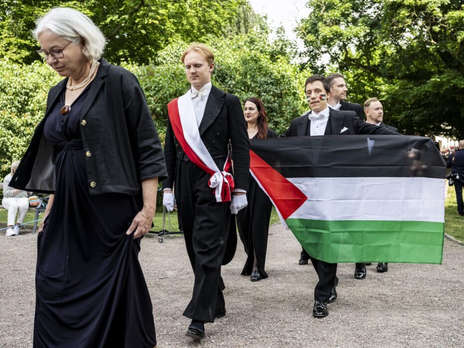 David Alcer hållandes en palestinaflagga under sin doktorspromotion.