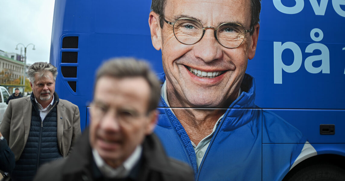 Ulf Kristersson framför en moderat valbuss med en bild av honom.