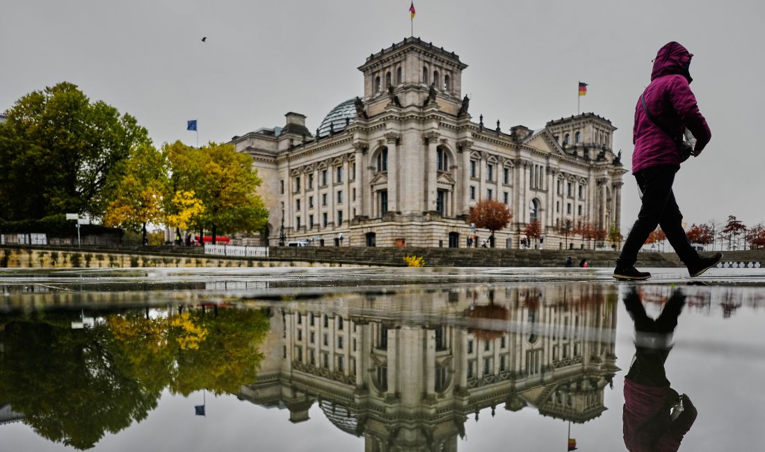 En kvinna går framför Reichstagsbyggnaden i Berlin.
