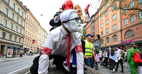 Tre utklädda personer på ett biltak.