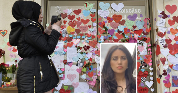 En flicka fotar pappershjärtan på en vägg.