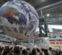 Banners och en stor jordglob hänger inne på COP30-området.