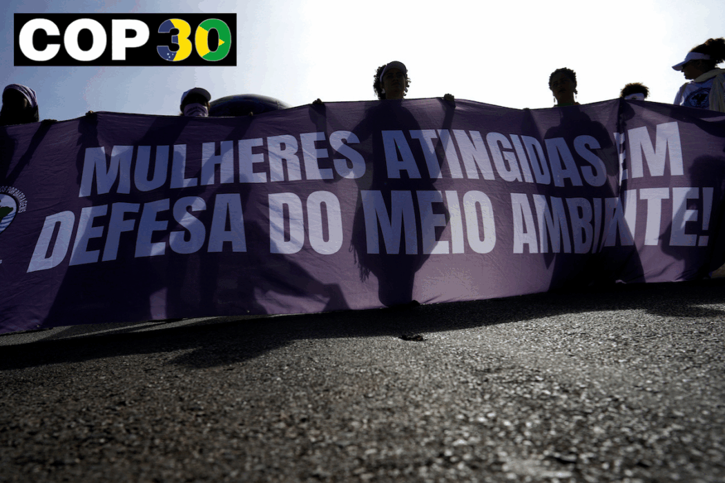 kvinnor bär banderoll med texten Kvinnor som drabbats i kampen för miljön. VInjett COP30
