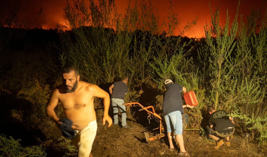 Invånarna försöker rensa skogen för att förhindra att den fattar eld när branden sprider sig i La Orotava på Teneriffa, Kanarieöarna, Spanien, lördagen den 19 augusti 2023.