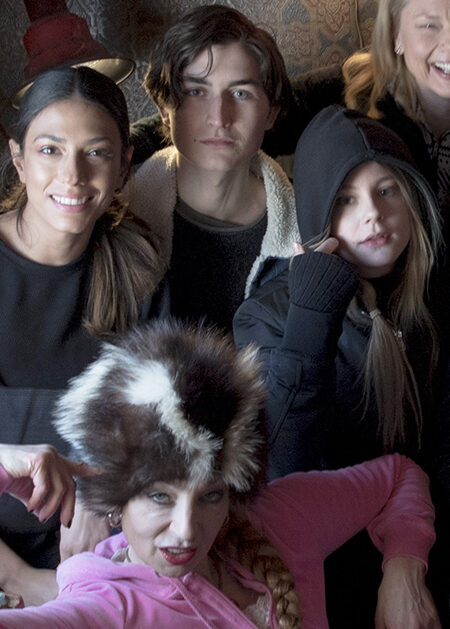 Leende människor i och vid en soffa.